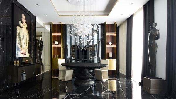 Sala da pranzo con lampadario scultoreo e marmo nero